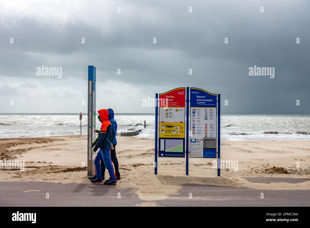 A view along an information sign on an empty Durely Chine beach at Bournemouth, Dorset, UK in April 2023 with grey skies as Storm Noa closes in. Stock Photo