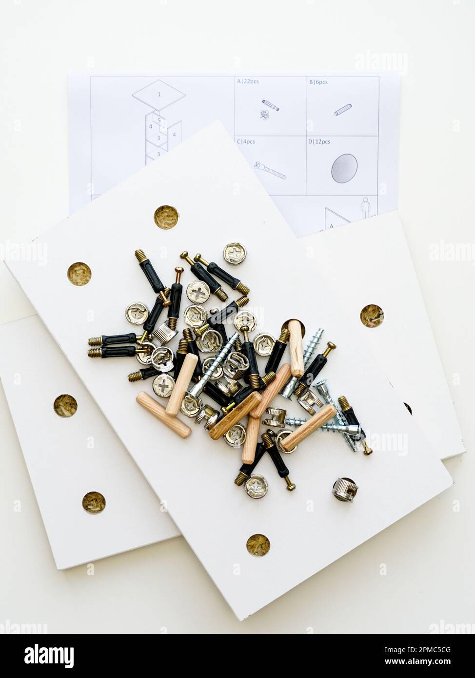 Furniture fittings. A pile of a various assembly fittings on a white