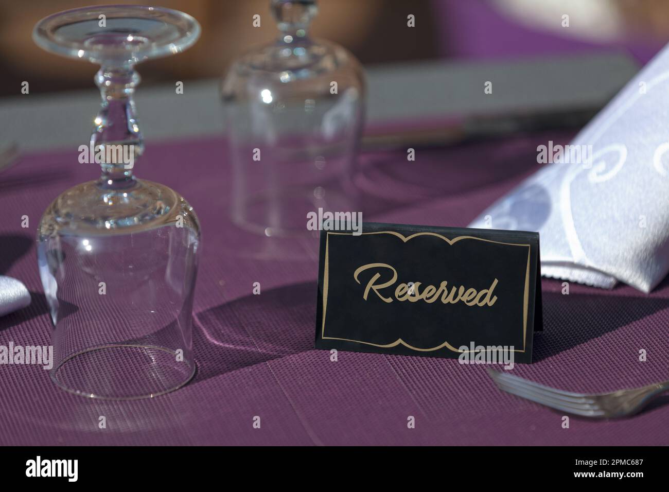 Table on the terrace of a restaurant with a sign saying “Reserved”. Stock Photo
