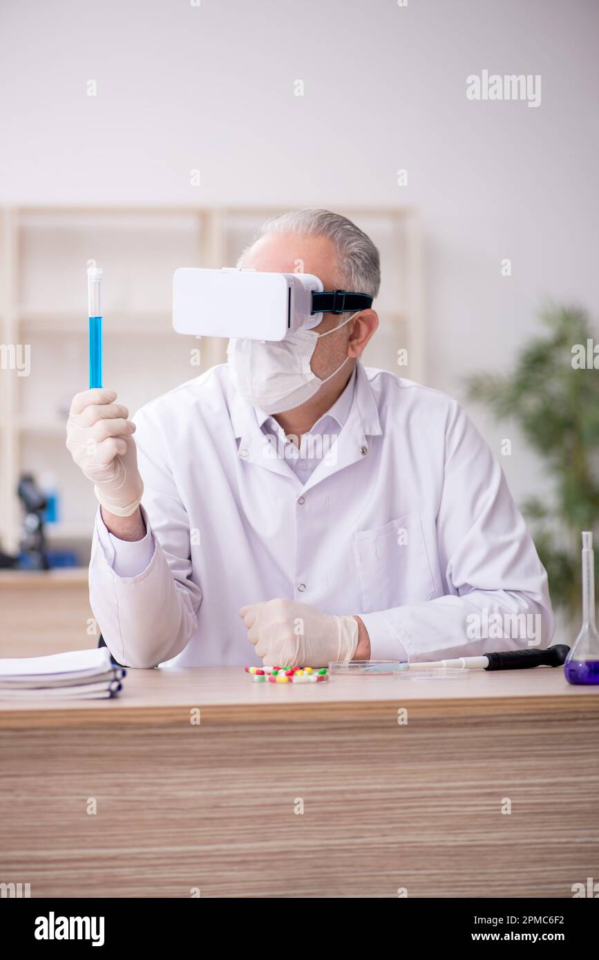 Old chemist wearing virtual glasses at the lab Stock Photo