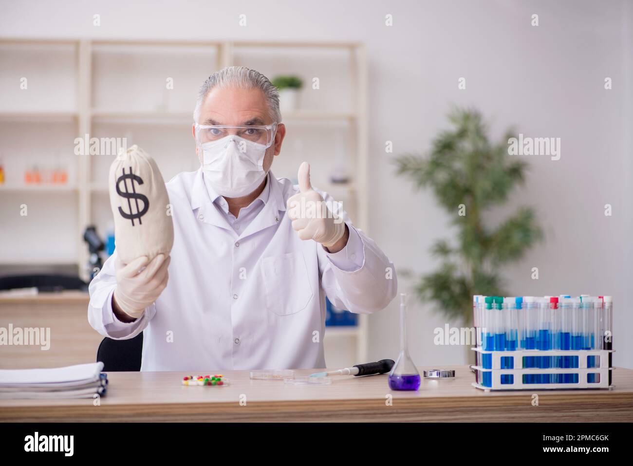 Old chemist in remuneration concept Stock Photo