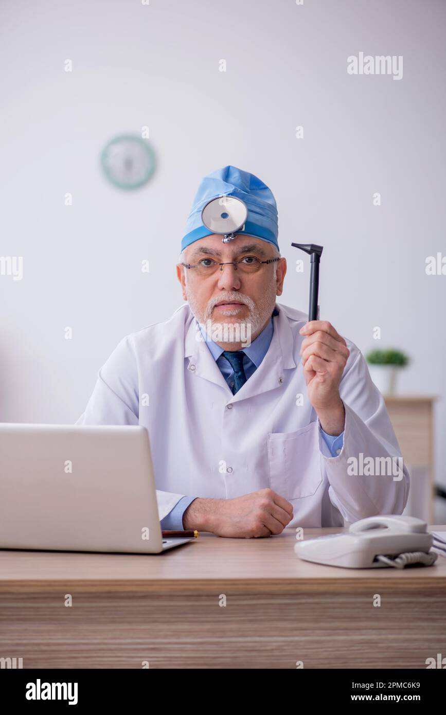 Old docror otolaryngologist working at the hospital Stock Photo