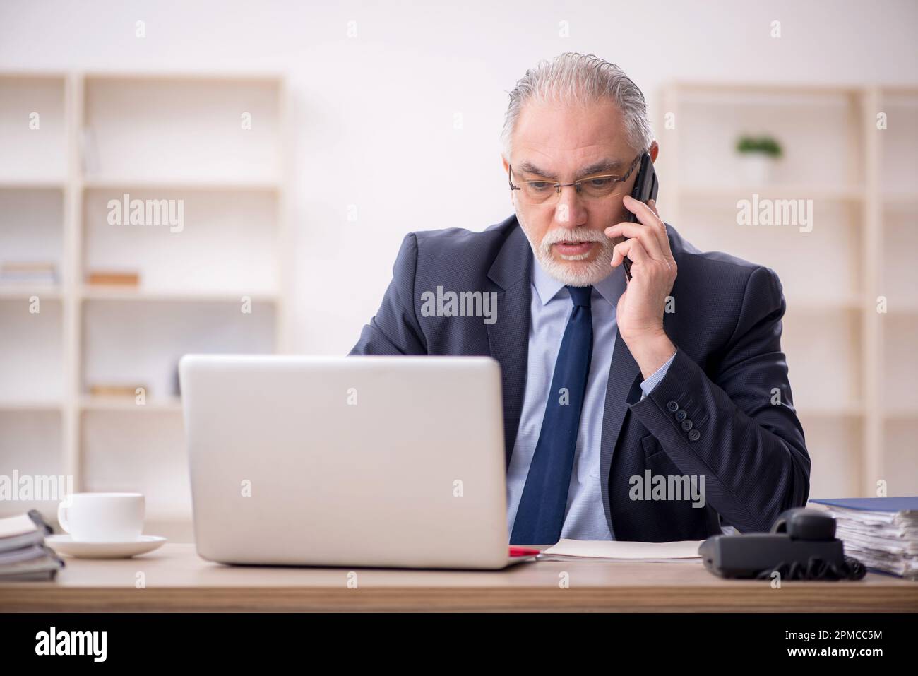 Old employee working at workplace Stock Photo - Alamy