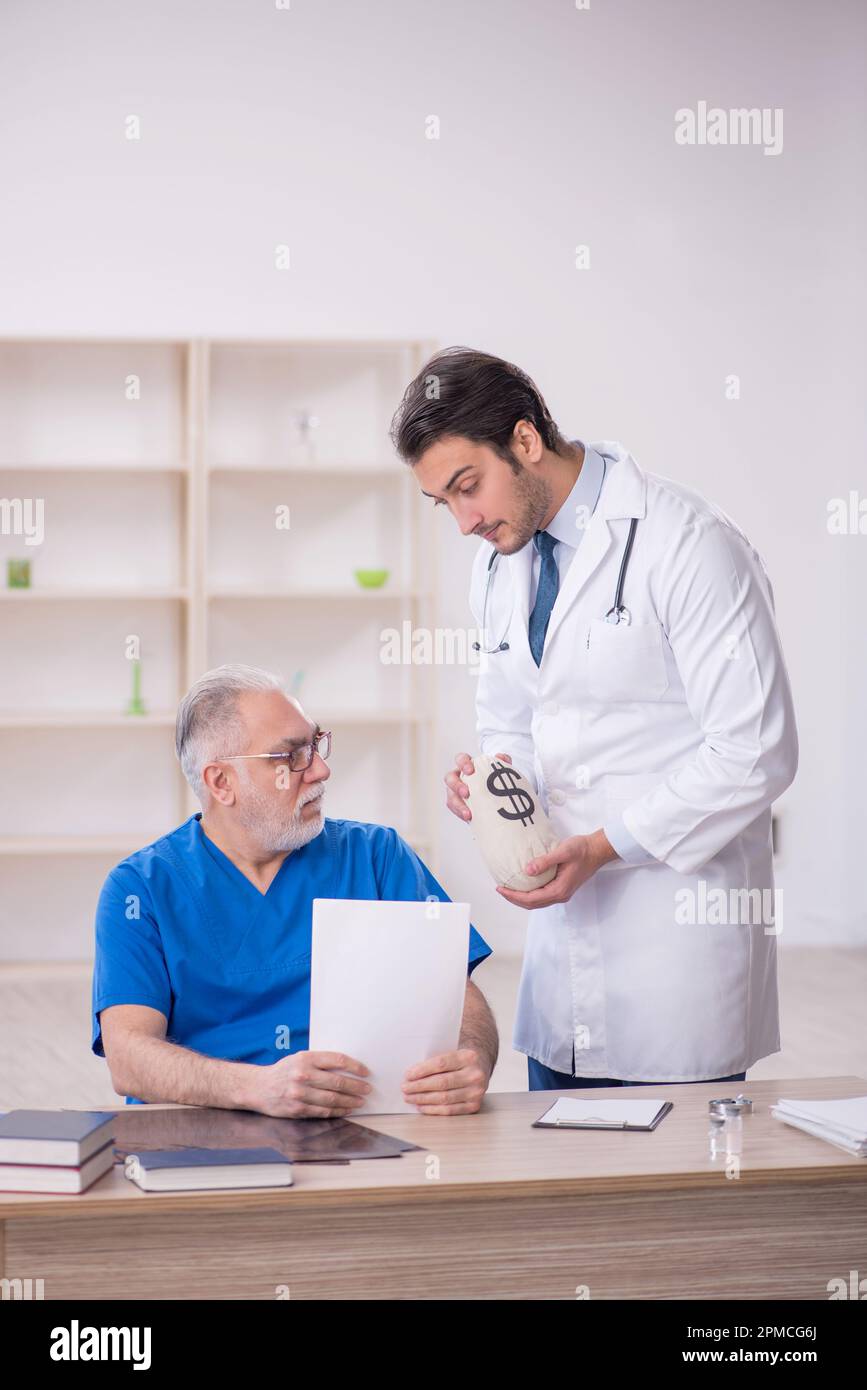 Two doctors in remuneration concept Stock Photo