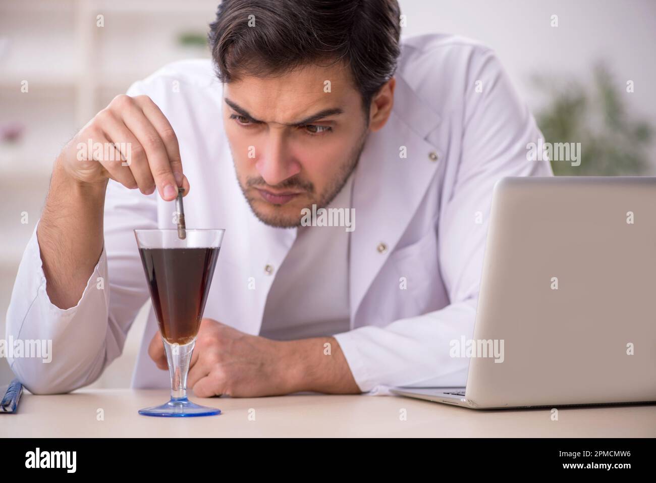 Young chemist examining soft drink at the lab Stock Photo Alamy