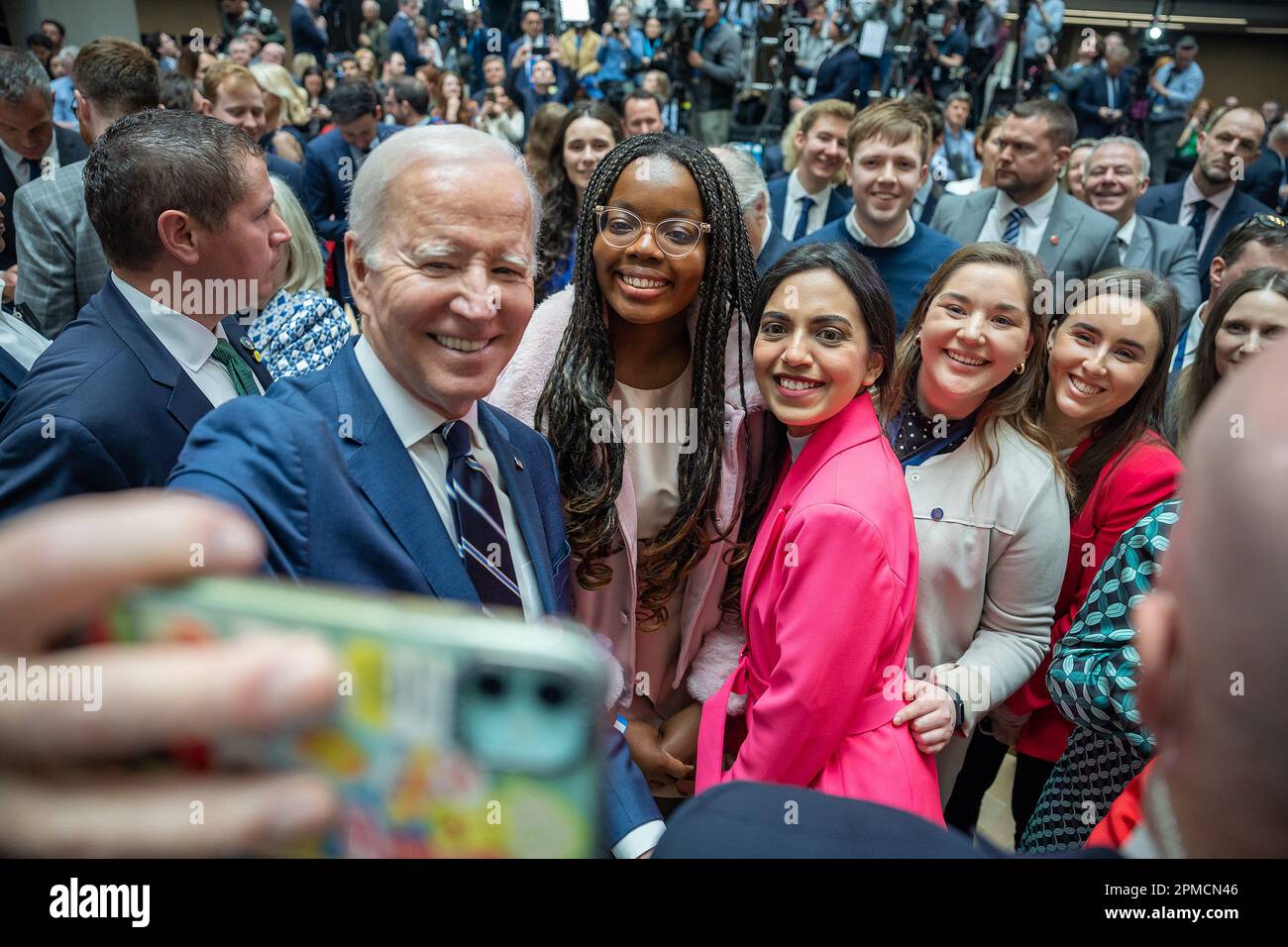 Belfast, Northern Ireland. 12th Apr, 2023. US President JOE BIDEN takes a selfie with guests after speaking at Ulster University in Belfast. (Credit Image: © White House via ZUMA Press Wire) EDITORIAL USAGE ONLY! Not for Commercial USAGE! Stock Photo