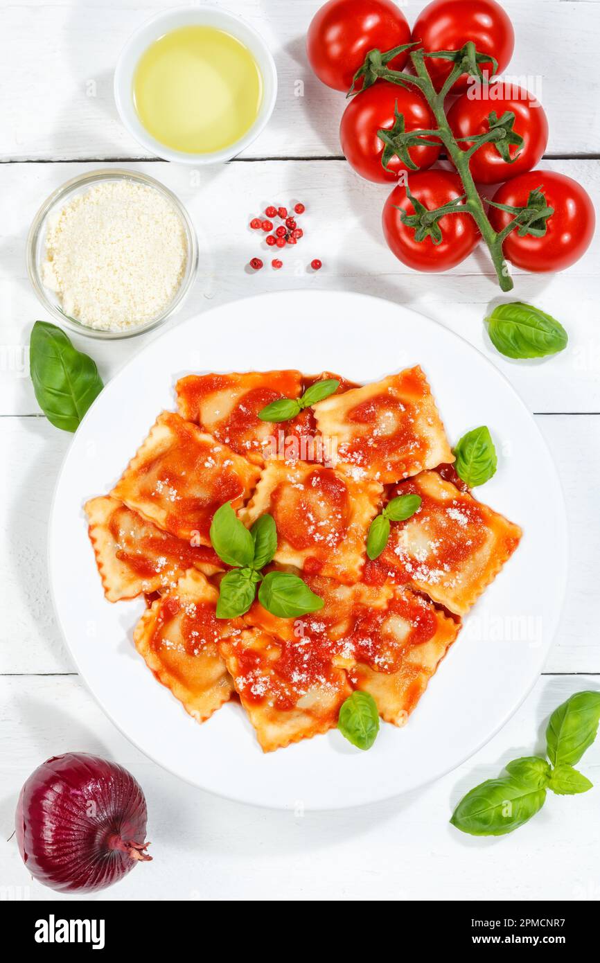 Ravioli pasta meal from Italy for lunch eat dish with tomato sauce top view on a plate and wooden board portrait format Stock Photo