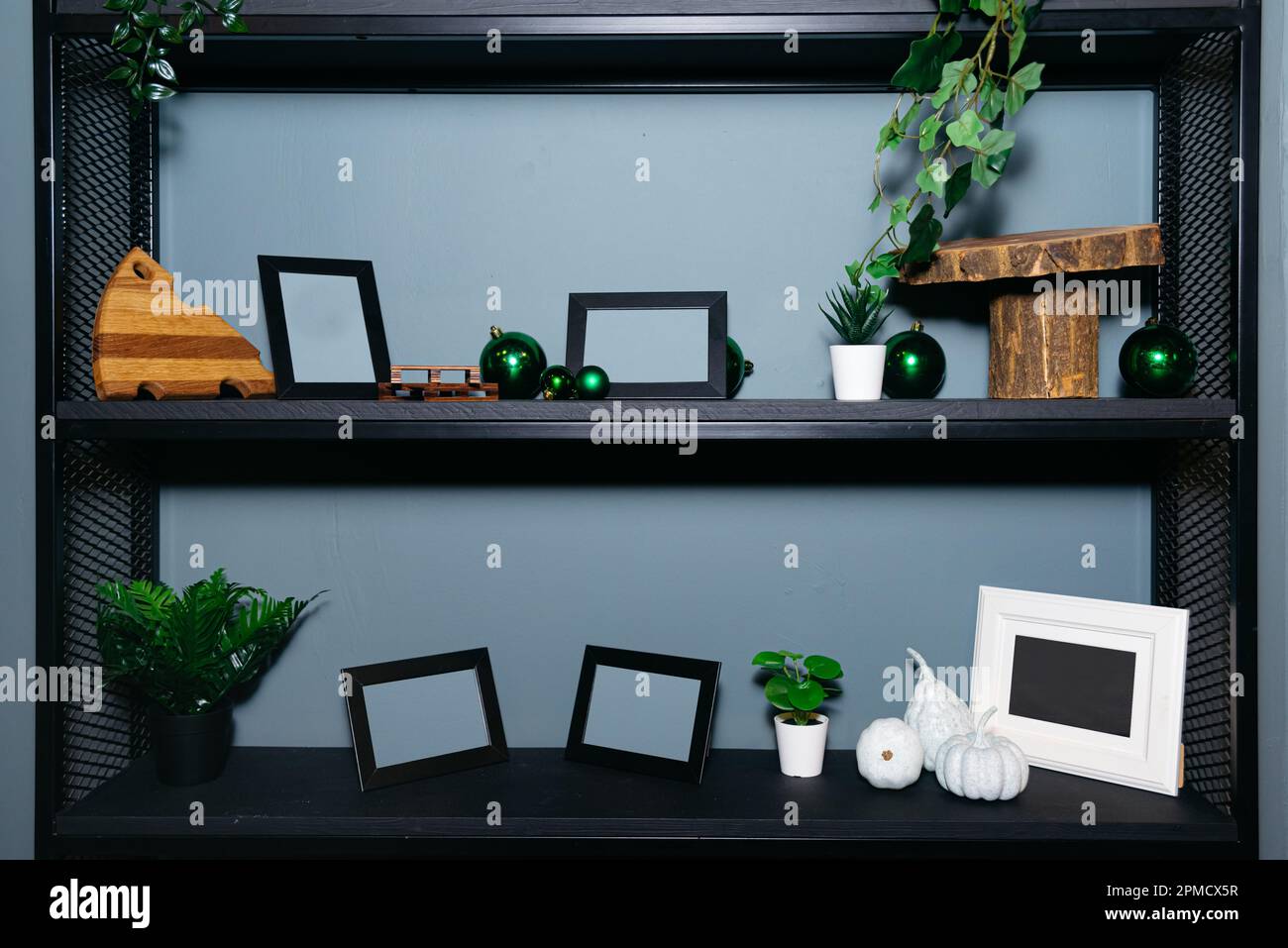 Wooden shelf painted black with blank photo frames and decorations