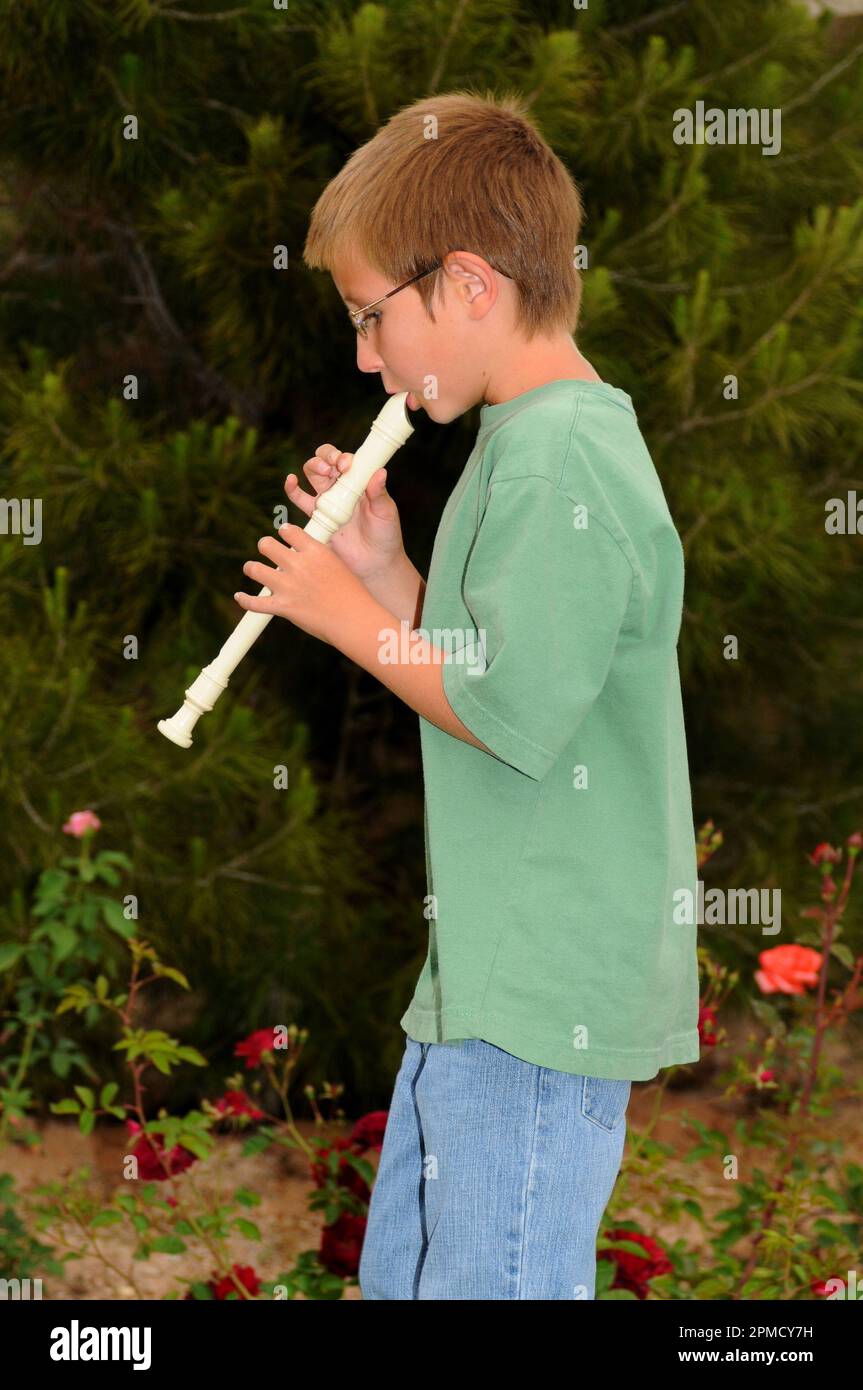 Young boy playing a recorder musical instrument Stock Photo Alamy
