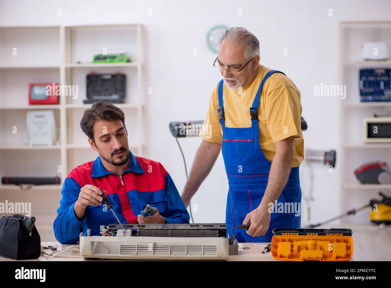 Two repairmen repairing airconditioner at Stock Photo Alamy