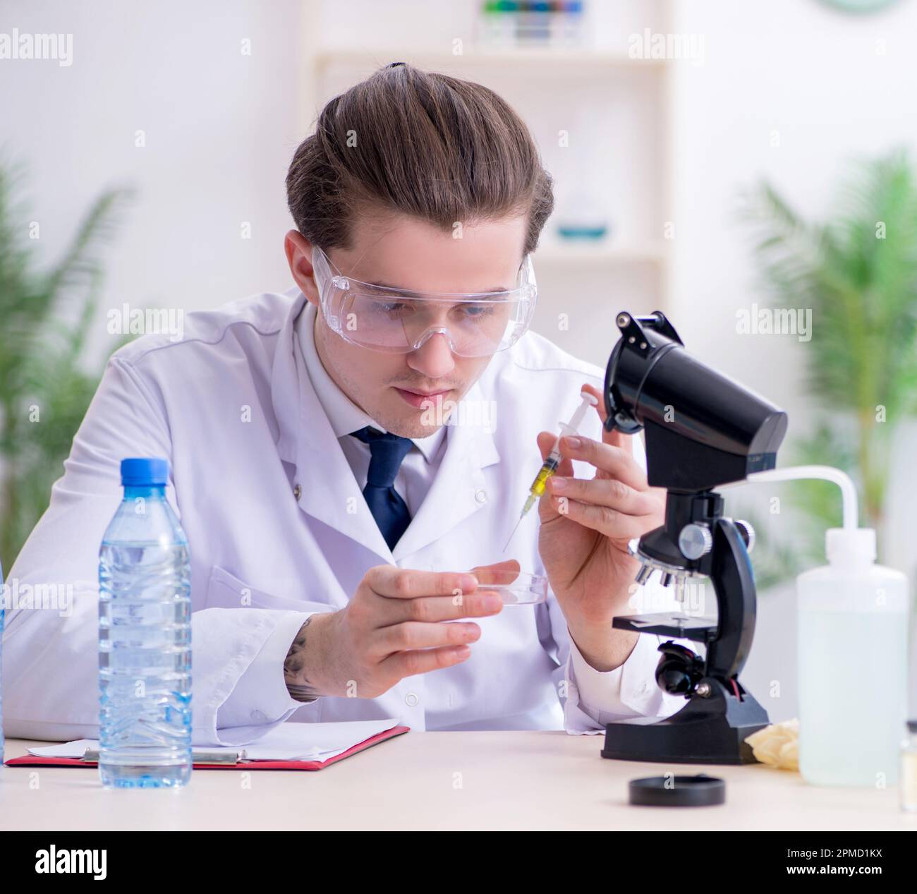 The young male chemist experimenting in lab Stock Photo - Alamy