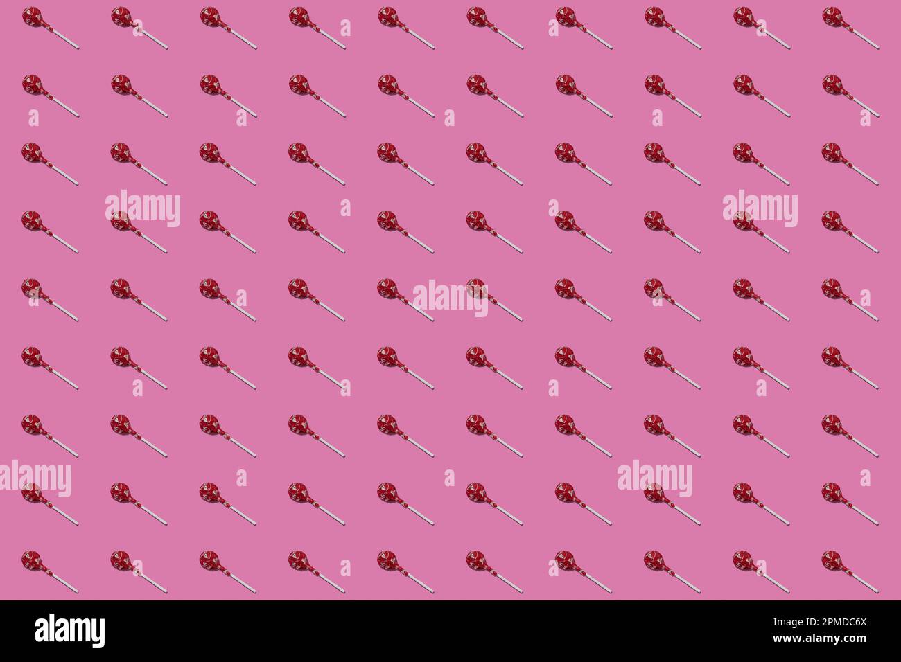 Lollipop Suckers with Red Wrappers in a Repeating Pattern on a Pink Seamless Background Stock Photo