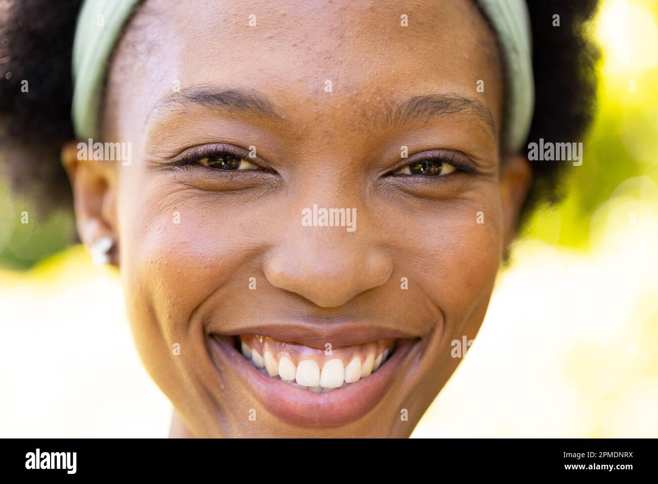 Closeup portrait of smiling african american mid adult woman in park Stock Photo