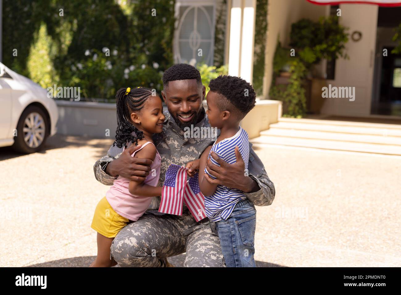 African american army soldier father embracing cute children outside house Stock Photo