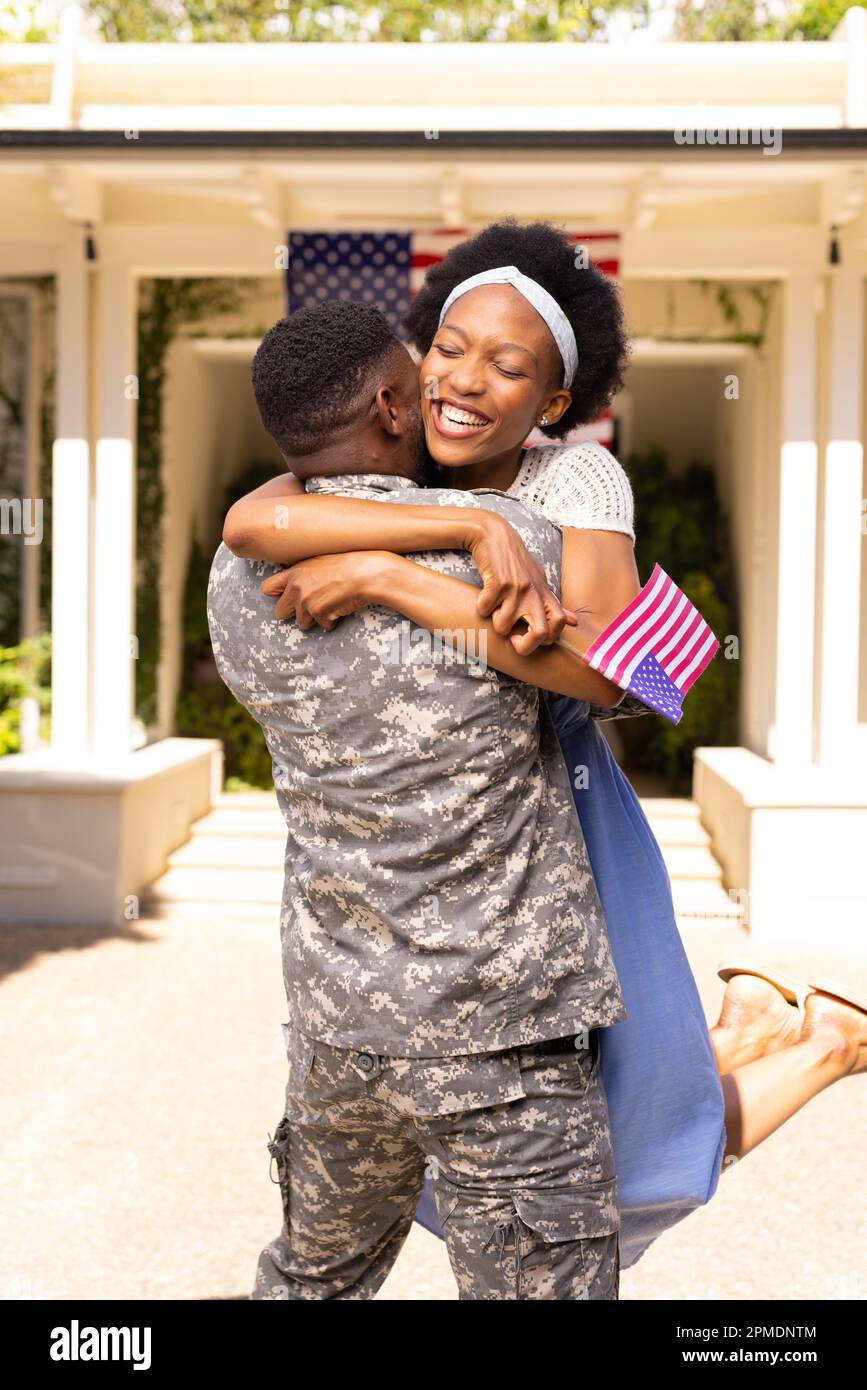 Cheerful excited african american wife embracing military husband after returning home from army Stock Photo