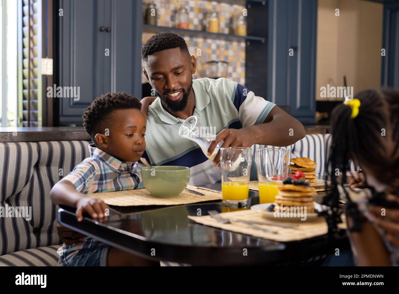 Mother And Son Are Smiling While Having A Breakfast In Kitchen. Mom Is  Pouring Milk Into Glass Stock Photo, Picture and Royalty Free Image. Image  83212891.