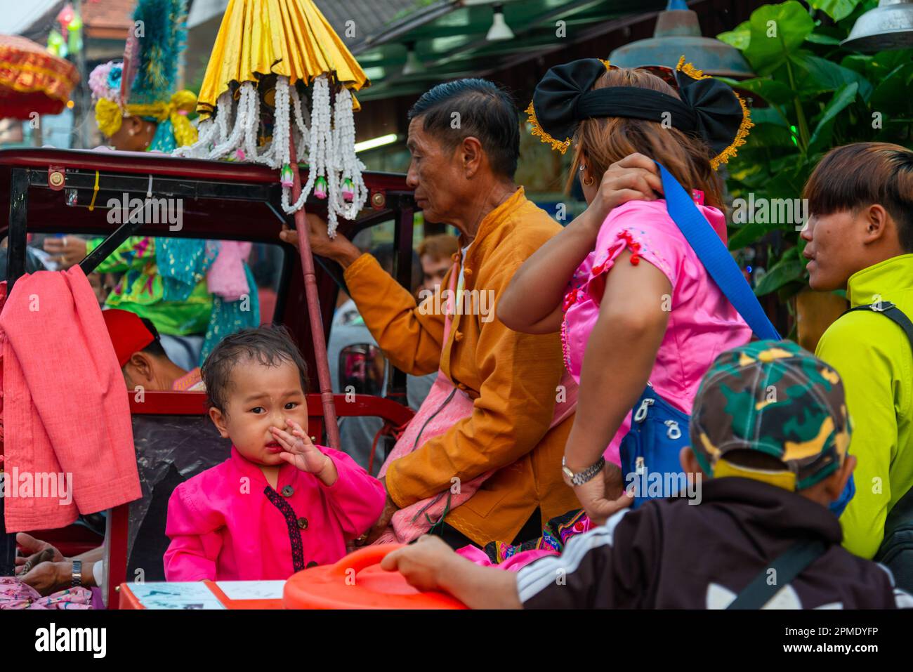 Pai,Thailand-April 4th 2023: A young child is temporarily upset,during the excitement of the loud,vibrant street festival,celebrating boys and adolece Stock Photo