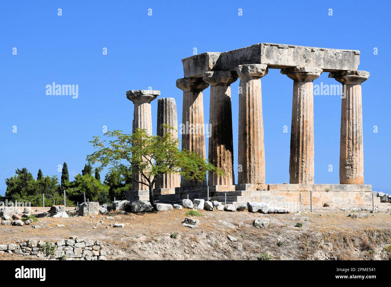 The ancient Temple of Apollo at the Corinth Archeological Site and museum in Corinth Greece' on a sunny day with blue sky. Stock Photo
