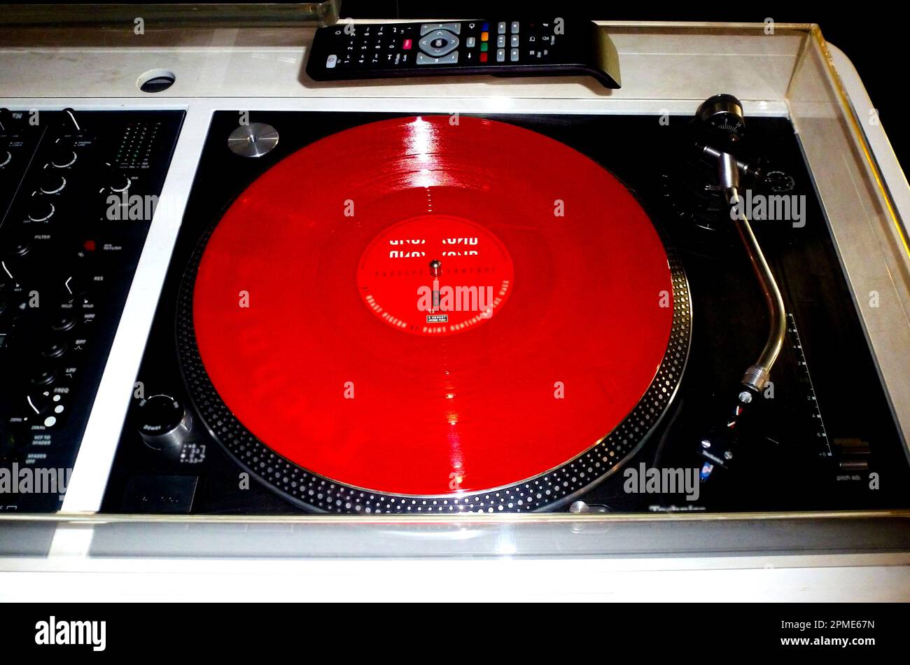 turntable closeup. red 45 speed LP record. silver metal finish. music