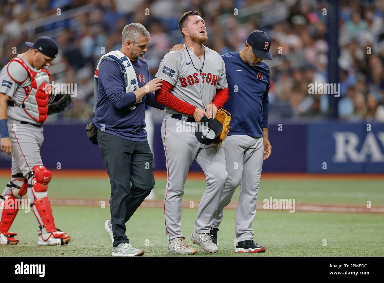 St. Petersburg, FL USA; Boston Red Sox relief pitcher Ryan Brasier (70) sustained an injury while pitching and is helped to the dugout during an MLB g Stock Photo