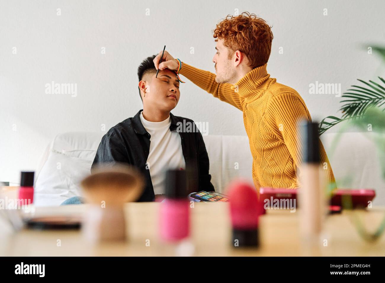 Gay couple applying make up at home Stock Photo