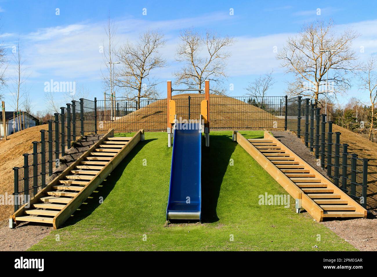 Outdoor slide flanked by wooden stairs at Kirkonkylän koulu preschool and primary school yard, Perniö, Salo, Finland. Stock Photo