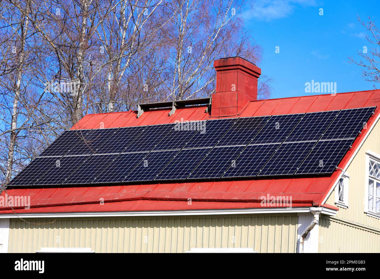 Solar panels on rooftop of a residential suburban house on a beautiful, sunny day in the spring. Stock Photo