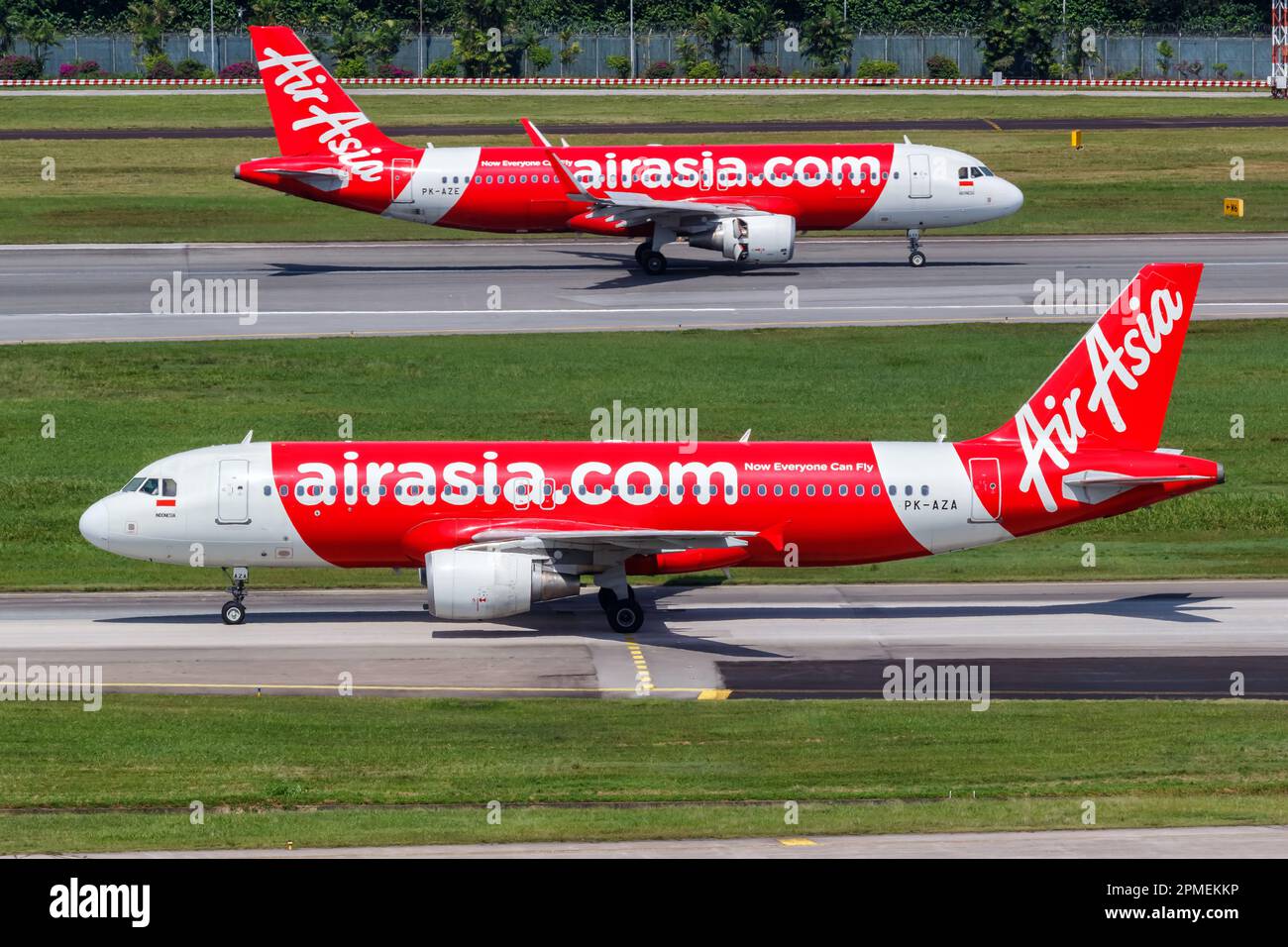 Changi, Singapore - February 3, 2023: Indonesia AirAsia Airbus A320 airplanes at Changi Airport (SIN) in Singapore. Stock Photo