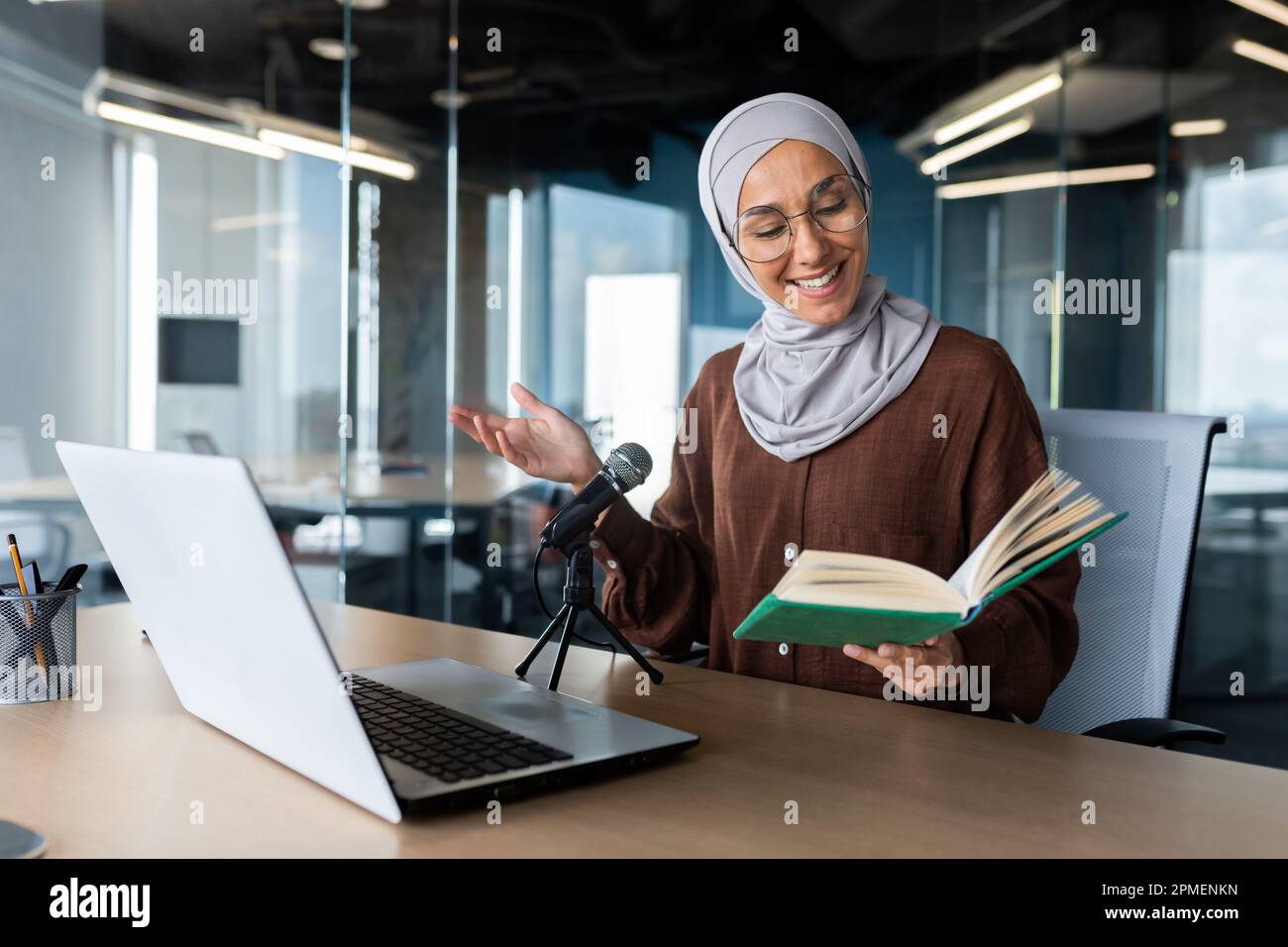 Young beautiful muslim woman in hijab working in modern office using ...