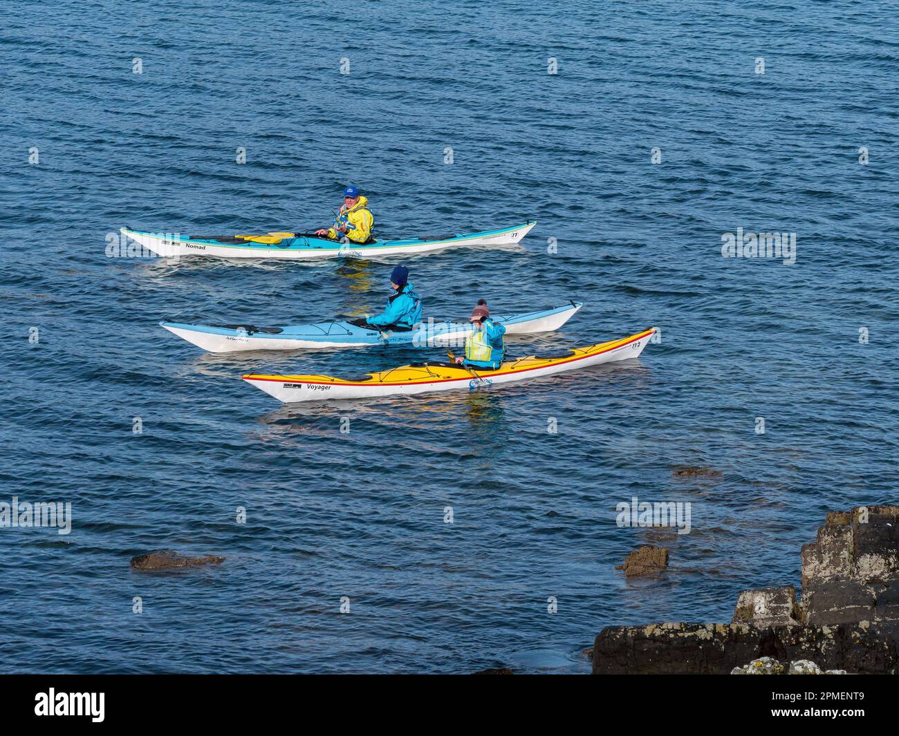 Three sea kayakers on Loch Eishort, Isle of Skye, Scotland, UK Stock Photo
