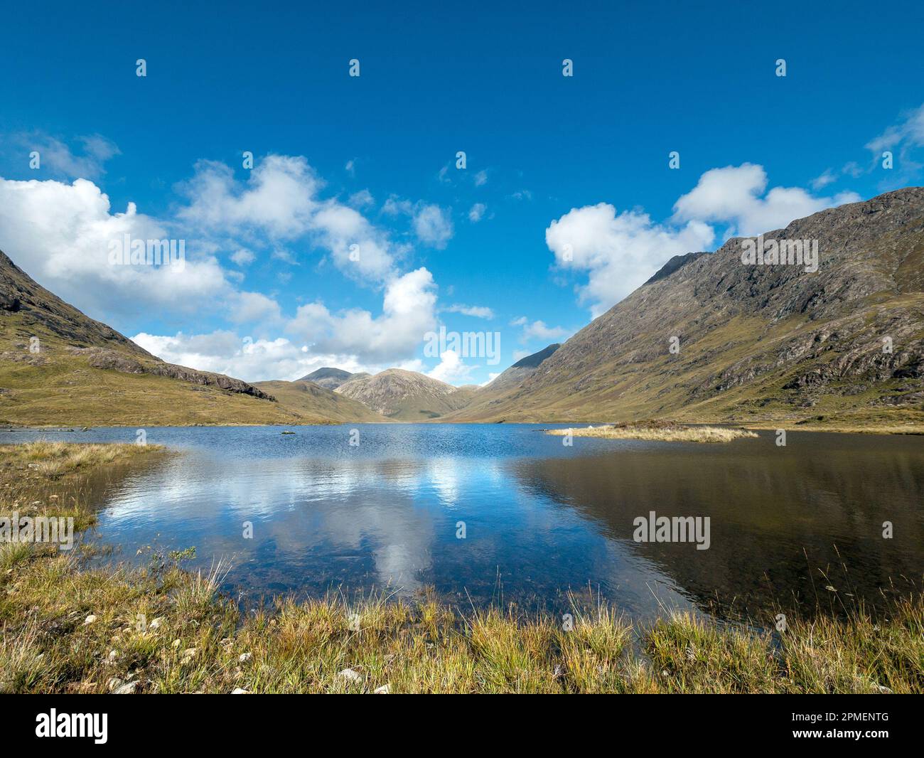 Still waters of Loch na Creitheach with Red Cuillin mountains in the distance, Camasunary, Isle of Skye, Scotland, UK Stock Photo