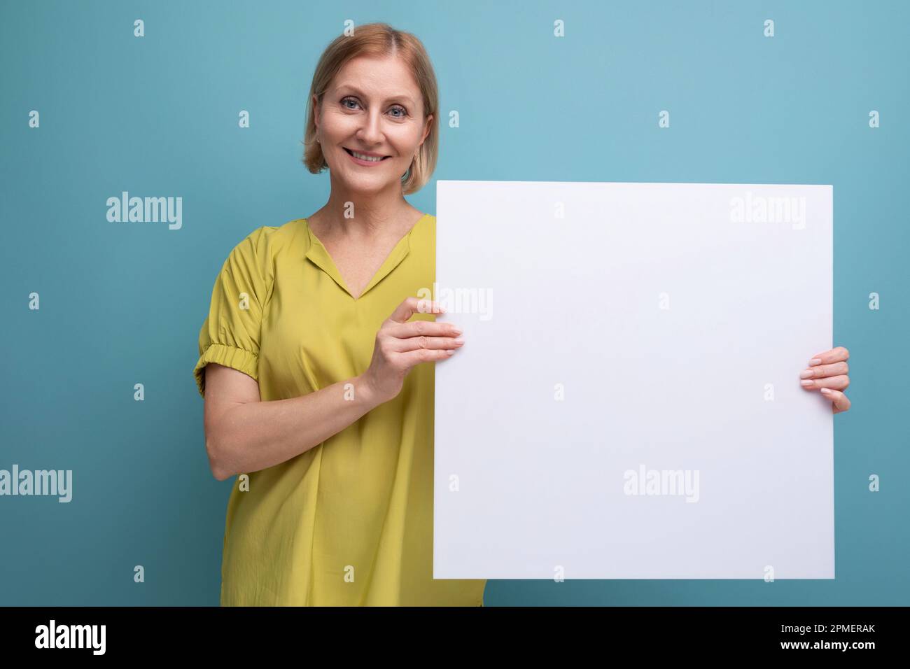 middle aged woman holding poster mockup for information Stock Photo - Alamy