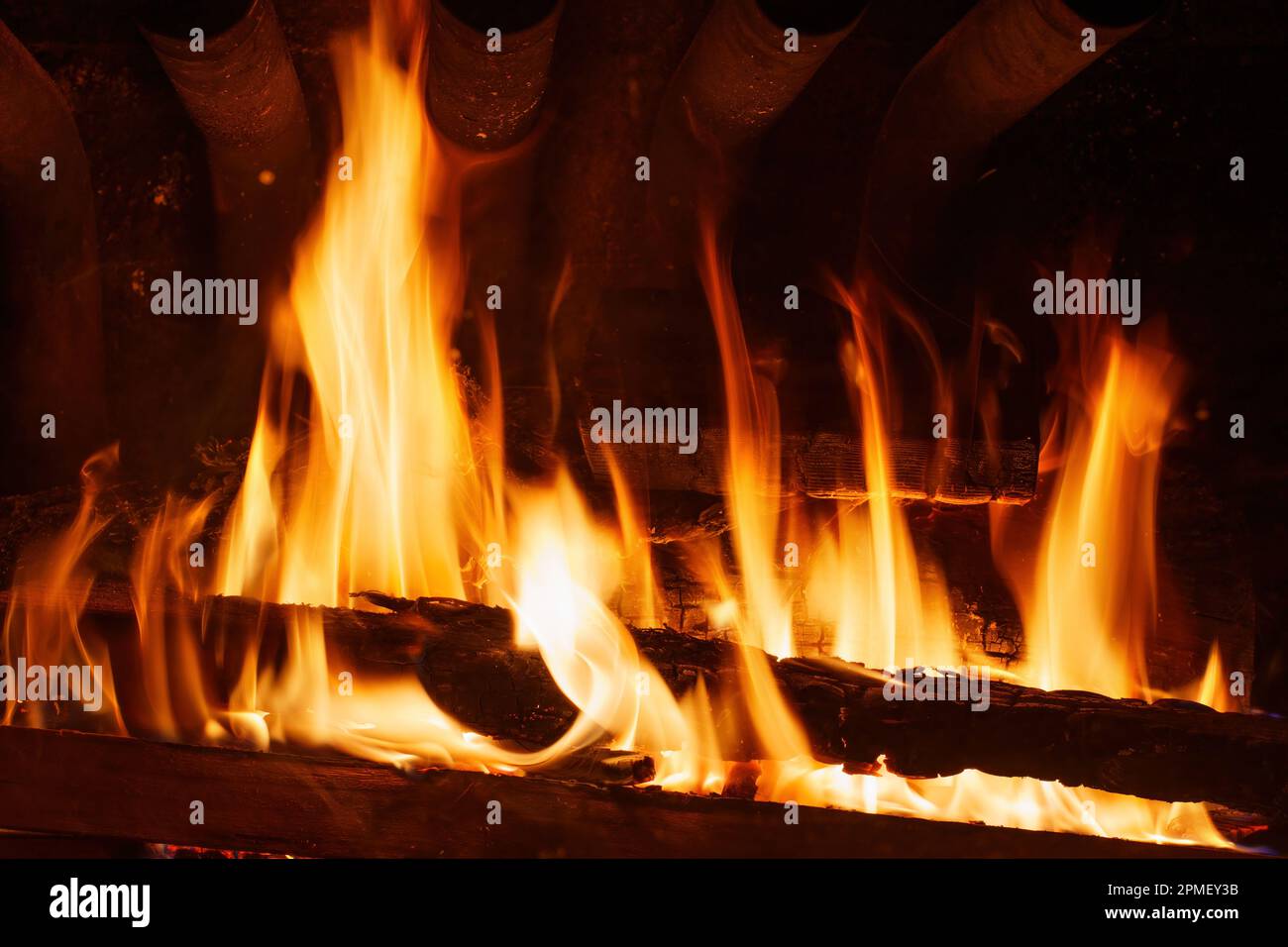 A roaring fire in a fireplace generates intense heat, as glowing flames
