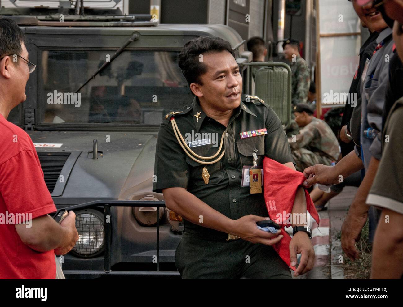 Red shirt protest Truth, Bangkok 2010. While International Media and Corporations with factories in Thailand are accusing the Prime Minister of underestimating the protest and non implementing any response against the 'terrorists”, on the streets, the military forces, the government did sent already, refuse to attack farmers and families, and jeopardised their own tanks, armed with sound waves.Bangkok chief Police, Coronel Sed Daeng and Red March leaders stand together against violence. Days later, Coronel Sed Daeng was shot in the head by a sniper, as predicted in our exclusive interview. Stock Photo