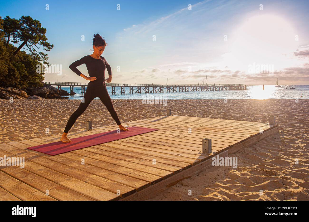 France, Vendee, Noirmoutier island, Noirmoutier en l'Ile, Ashtanga Yoga teacher in training near the landing stage of the Ladies beach, at sunrise Stock Photo