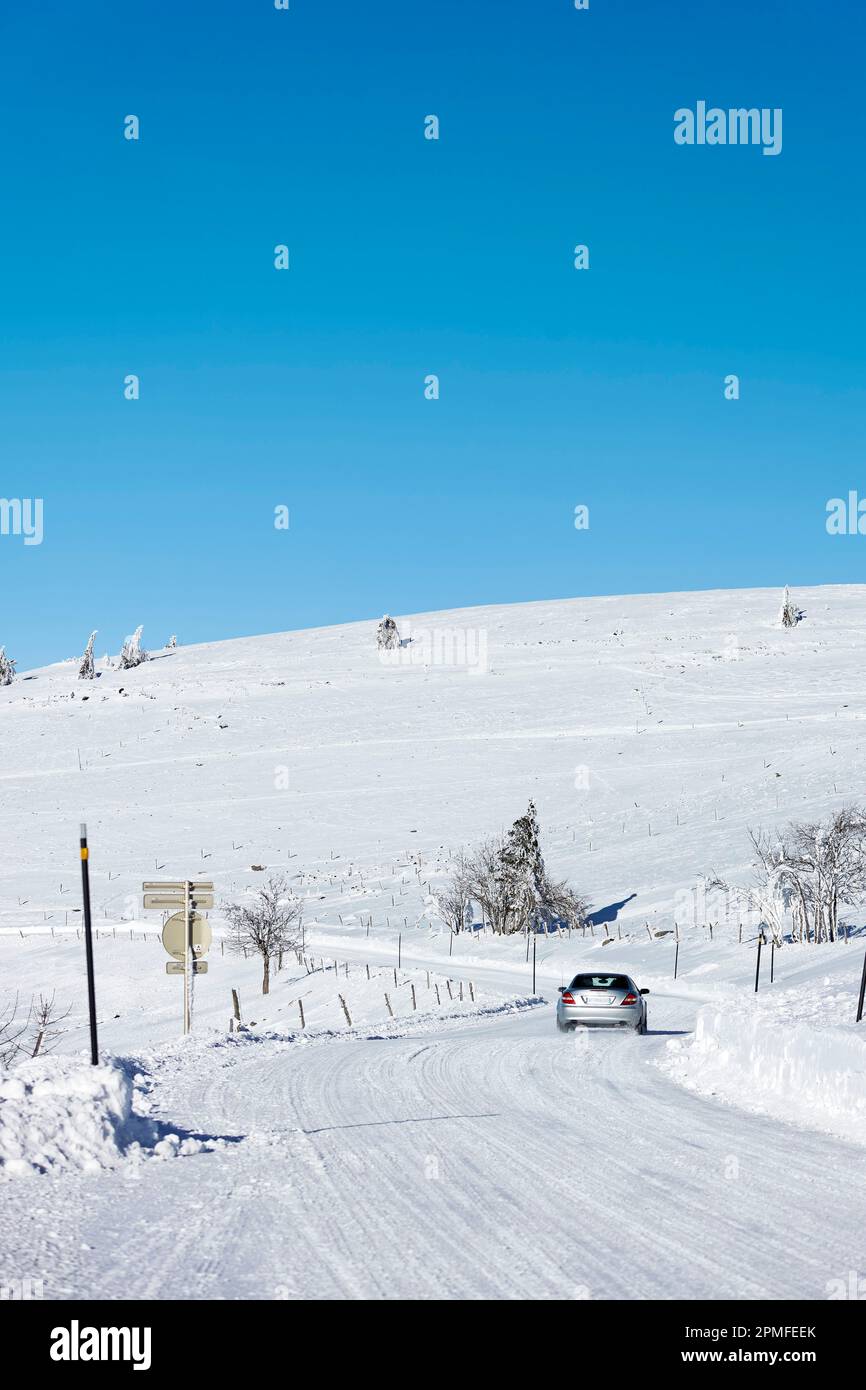 France, Vosges (88), Ballons des Vosges Regional Natural Park, La Bresse, car driving on the Route des Crêtes under the snow Stock Photo