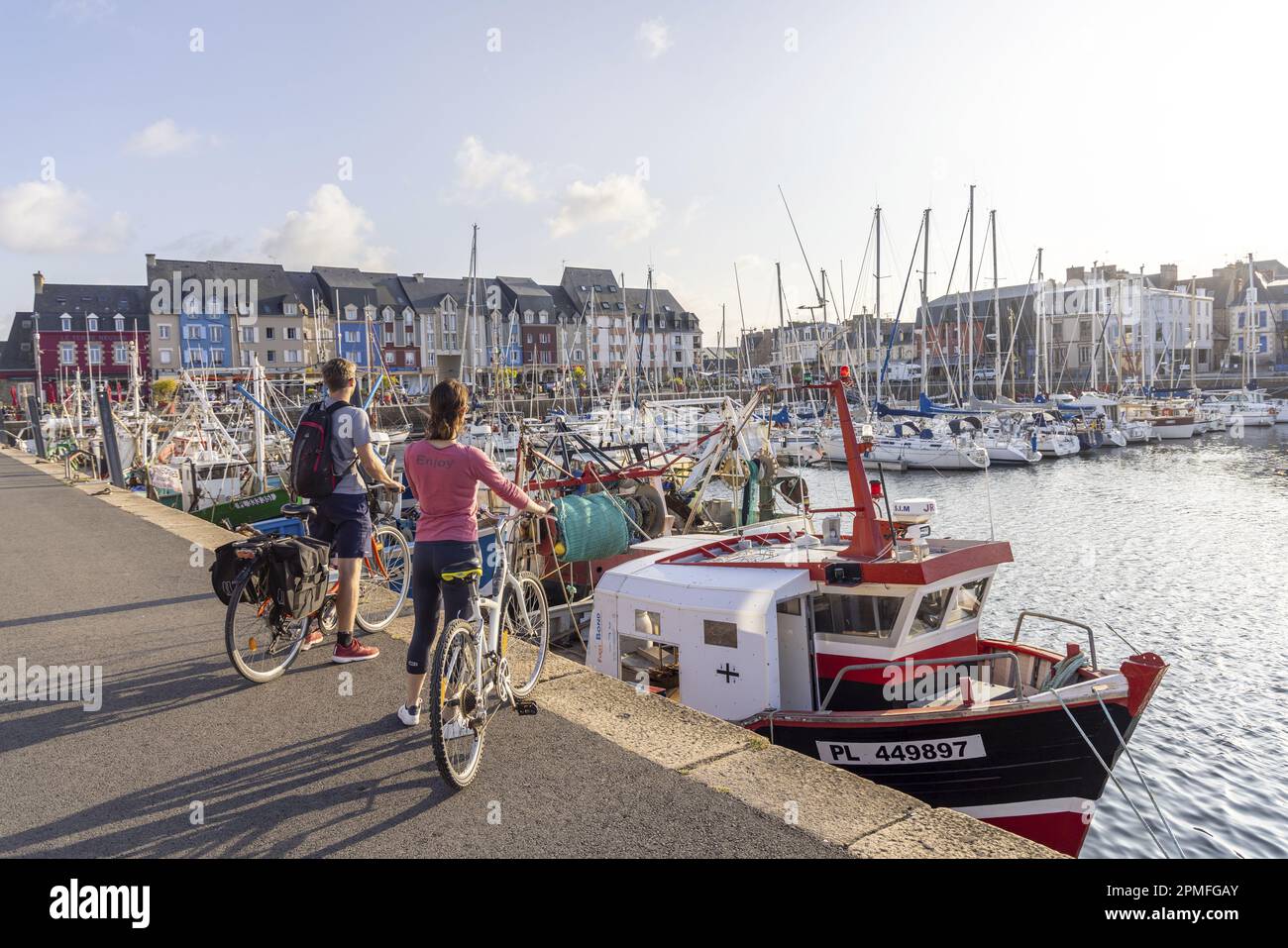 France, Cotes d'Armor, Paimpol, couple on a bike in front of the fishing port Stock Photo