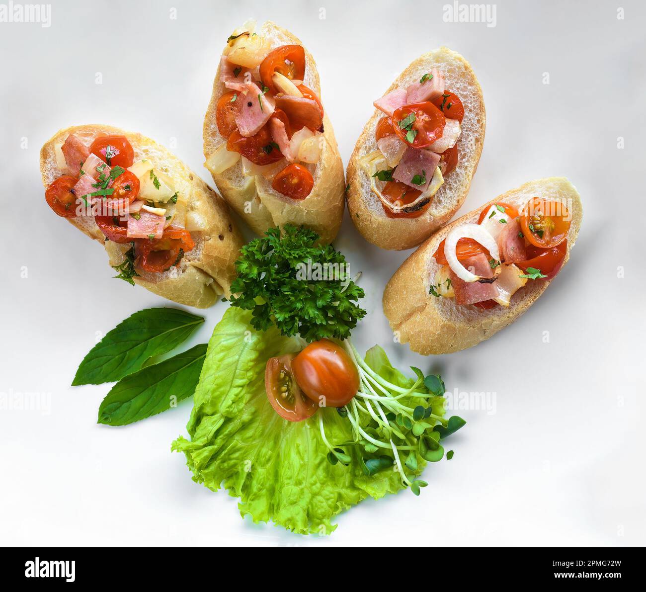 Bruschetta with tomatoes, ham,onion and olive oil on white plate close up Stock Photo
