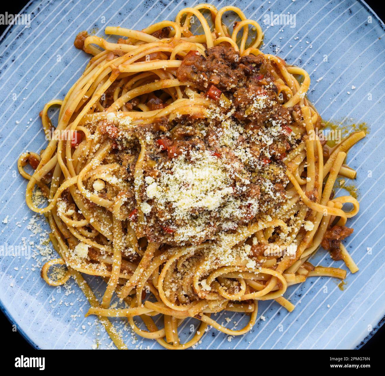 Pasta bolognese on blue plate   isolated on black background top view Stock Photo
