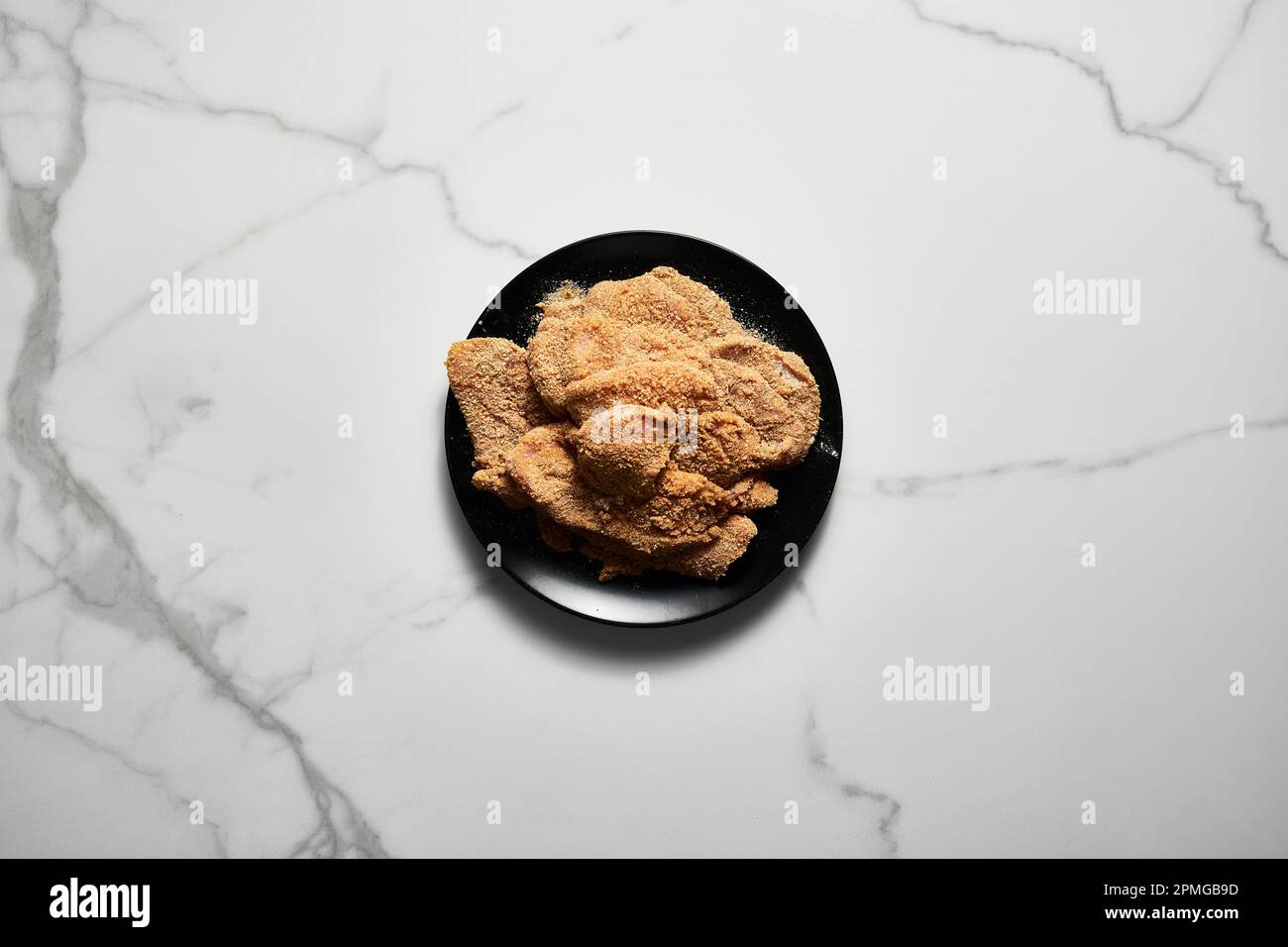 Raw Chicken schnitzel billet es calliope in breadcrumbs. On white