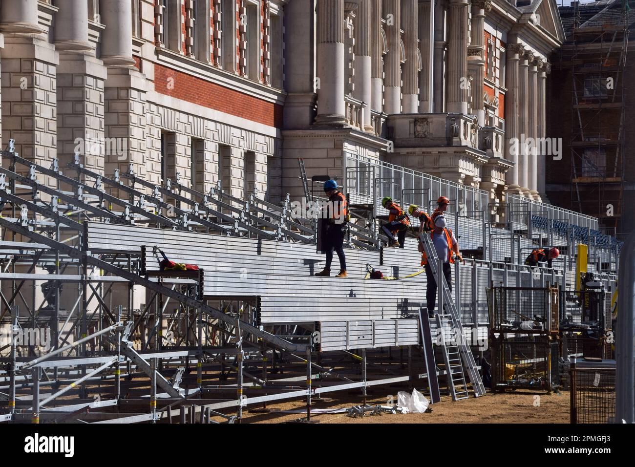 London, UK. 13th April 2023. Workers install seats at Horse Guards Parade as preparations for