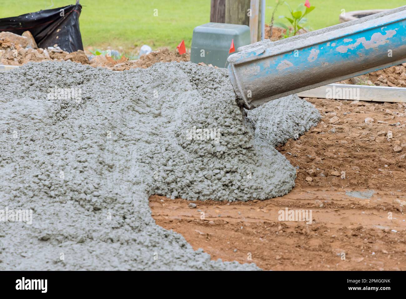 Concrete construction contractor pours wet concrete for pavering