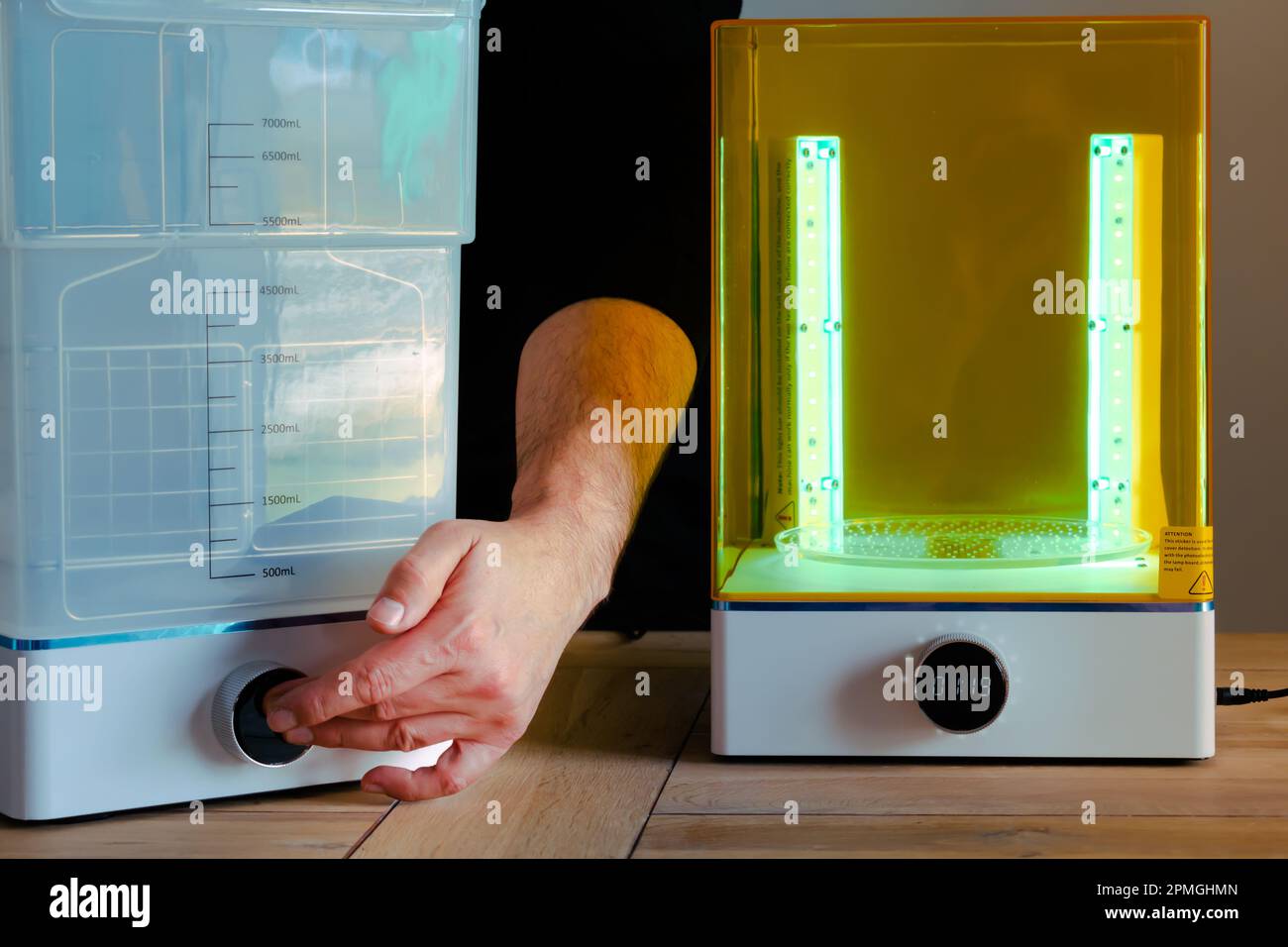 Man adjusting a wash and cure machine using UV light before use, for 3d