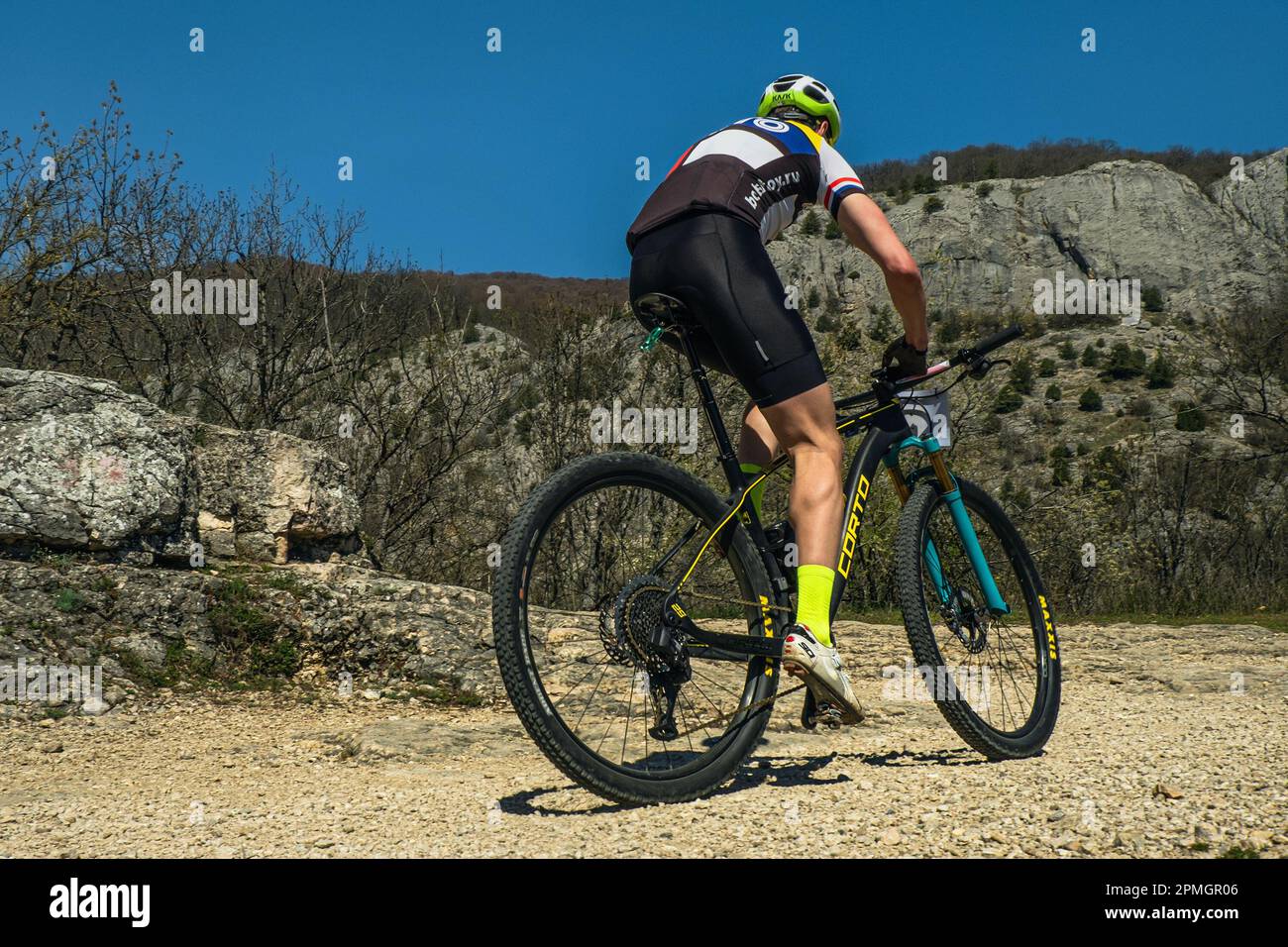 Yalta, Russia - May 2, 2021: cyclist riding mountain bike uphill cross-country cycling. Corto bikes, Maxxis tires, Sidi road shoes, Kask helmet Stock Photo