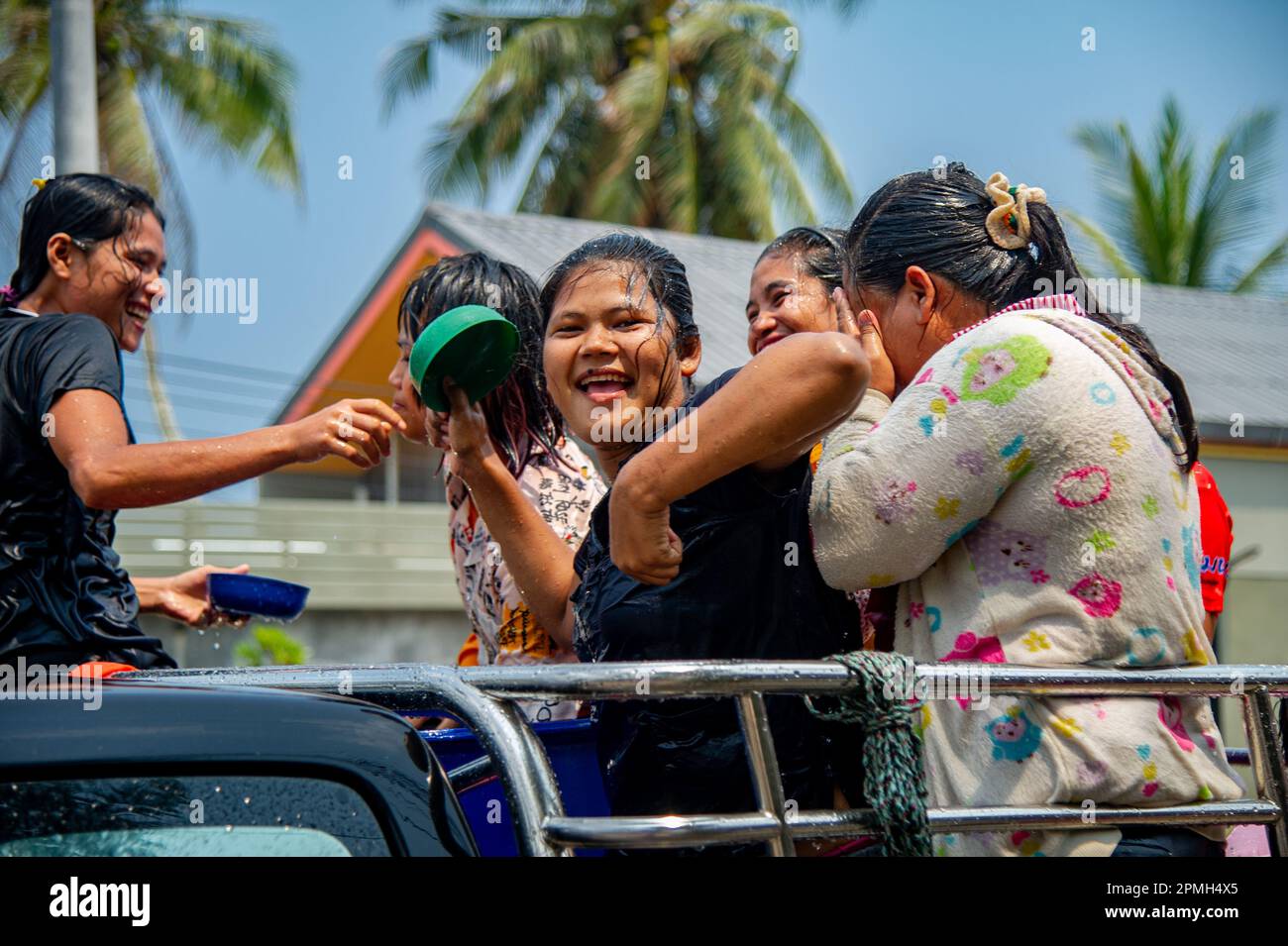 April 13 2023-Thung Wua Laen Beach - Chumphon area: Crowds celebrate Songkran, Thai New Year, by splashing each other with colored water or painting e Stock Photo