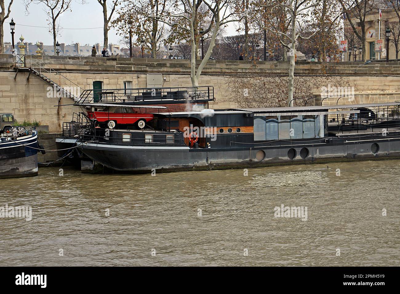 PARIS, FRANCE - DECEMBER 2, 2017  a barge moored on the banks of the River Seine Stock Photo