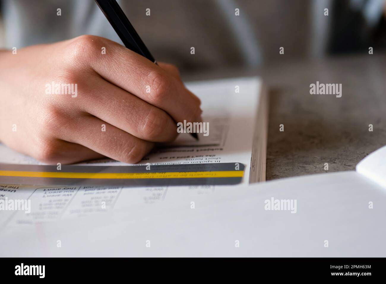 Kid affected by dyslexia doing homework, writing, reading notebook task ...