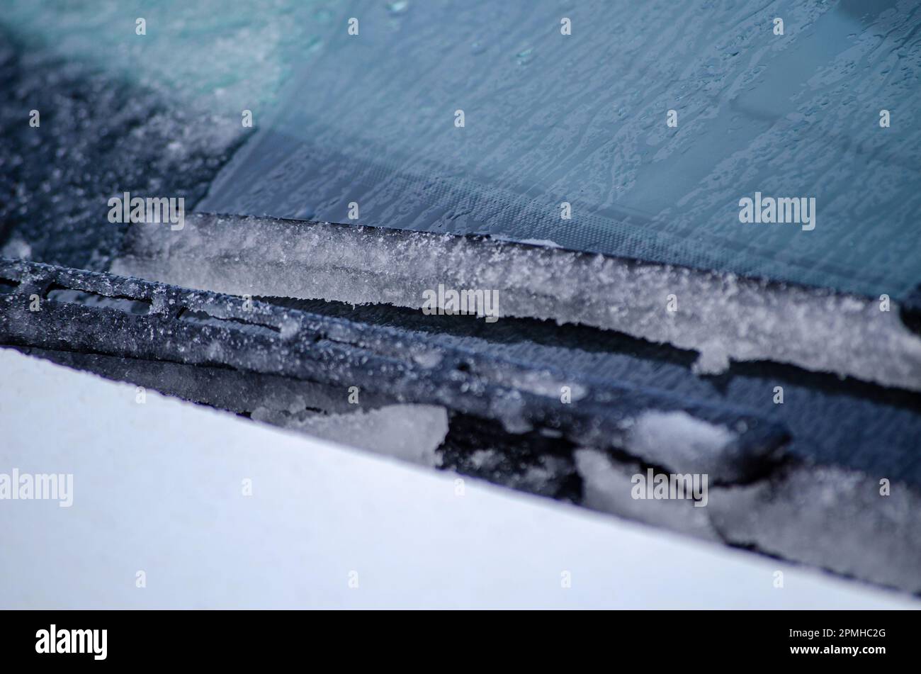 Selective focus, windshield wiper of a car covered with snow ice Stock Photo