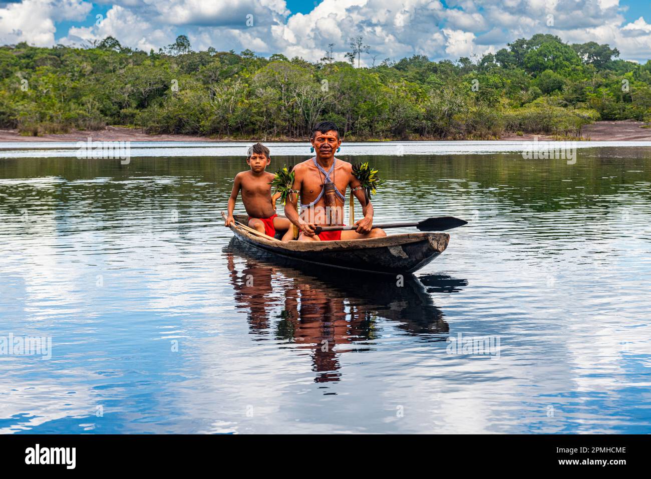 Father and son from the Yanomami tribe in a canoe, southern Venezuela, South America Stock Photo