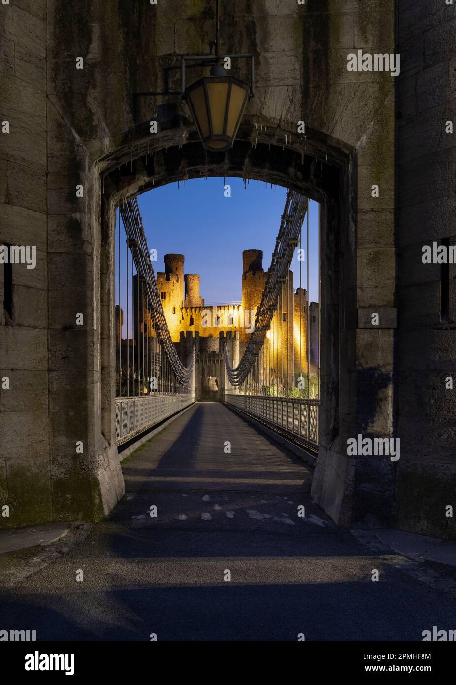Entrance to Telford's Conwy Suspension Bridge and Conwy Castle at night, UNESCO World Heritage Site, Conwy, North Wales, United Kingdom, Europe Stock Photo
